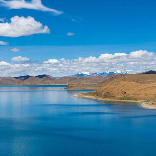 Der türkisblaue Yamdrok-See in Tibet vor der beeindruckenden Kulisse des Himalayas.