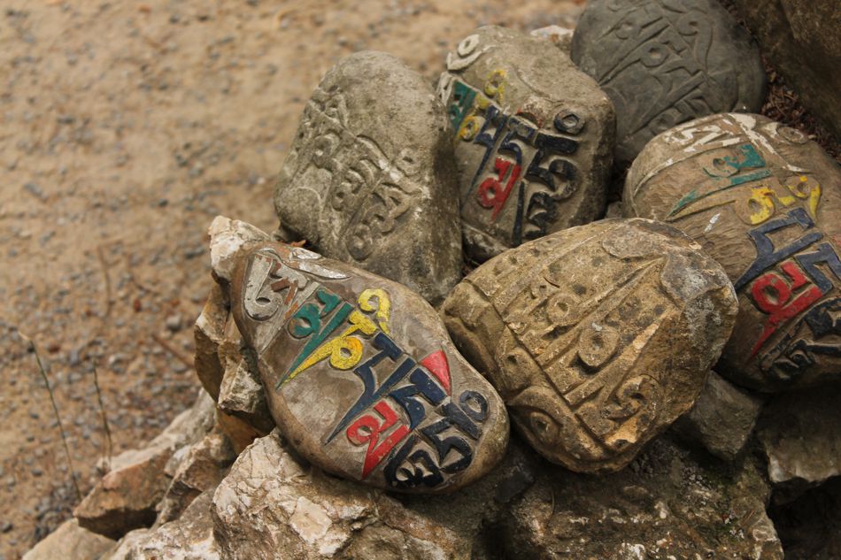 Bemalte Mani-Steine mit buddhistischen Gebeten und Mantras in Tibet.