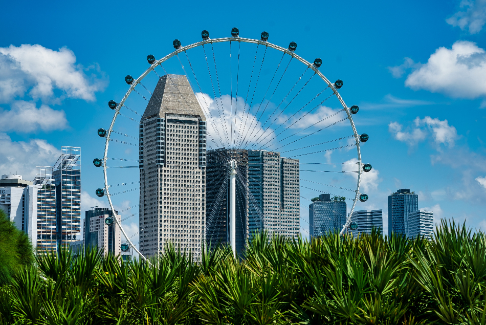 Singapore Flyer mit Wolkenkratzern vor blauem Himmel