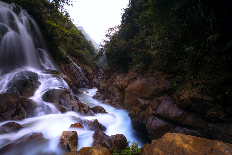 Wasserfall zwischen Felsen und dichtem Grün in Nordvietnam