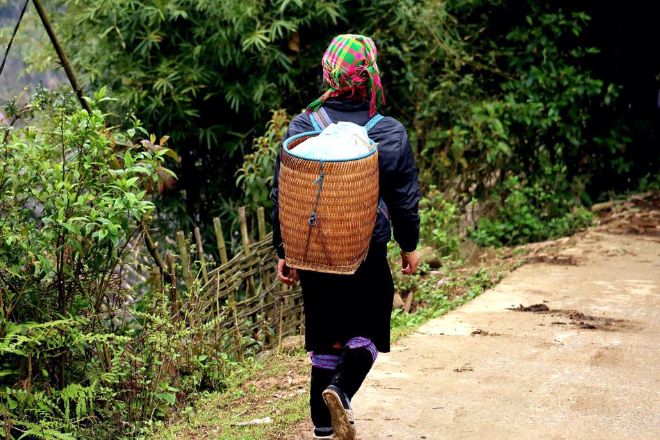 Frau mit traditionellem Tragekorb auf einem Bergpfad in Nordvietnam